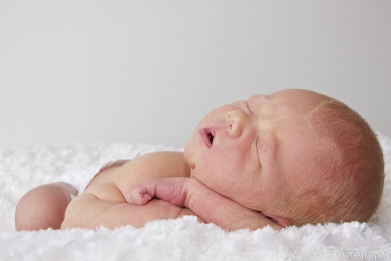 Newborn baby sleeping on his arms - newborn portrait photography